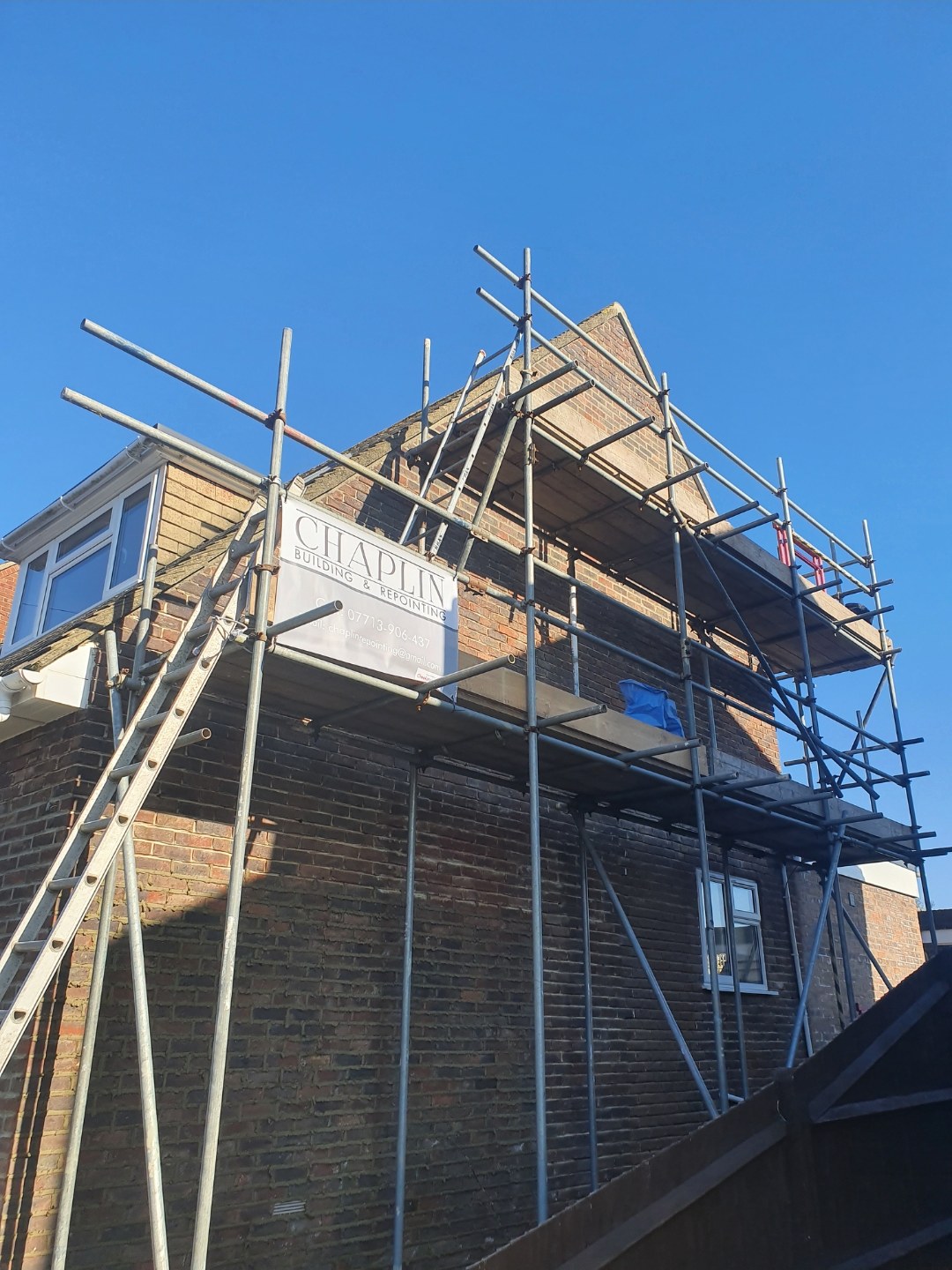 House under scaffold with a Chaplin Building & Repointing banner