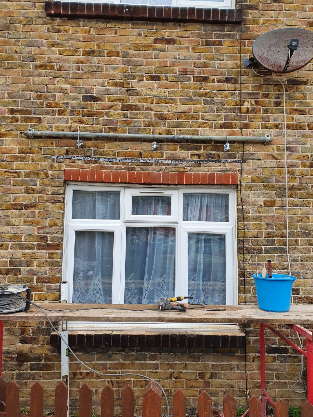 Yellow stock brickwork part-way through repointing